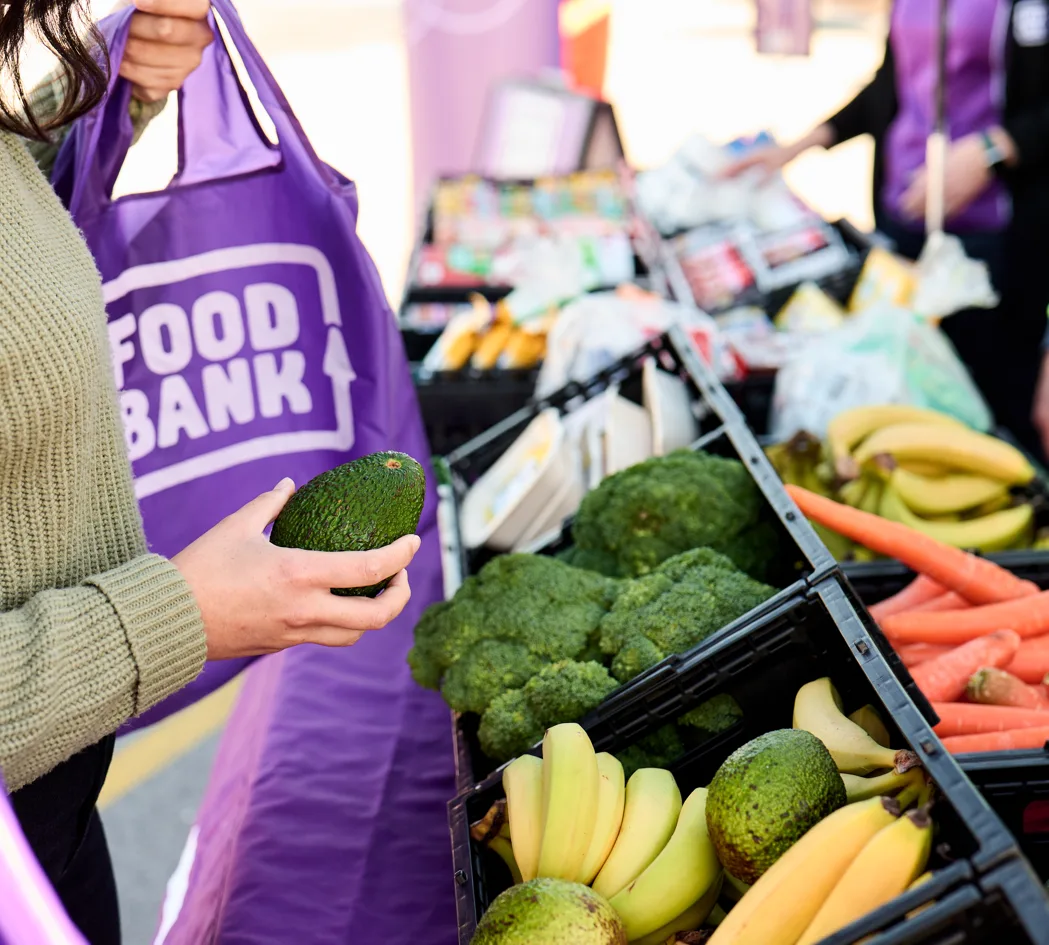 Fresh fruit and vegetables being packed into a Foodbank bag