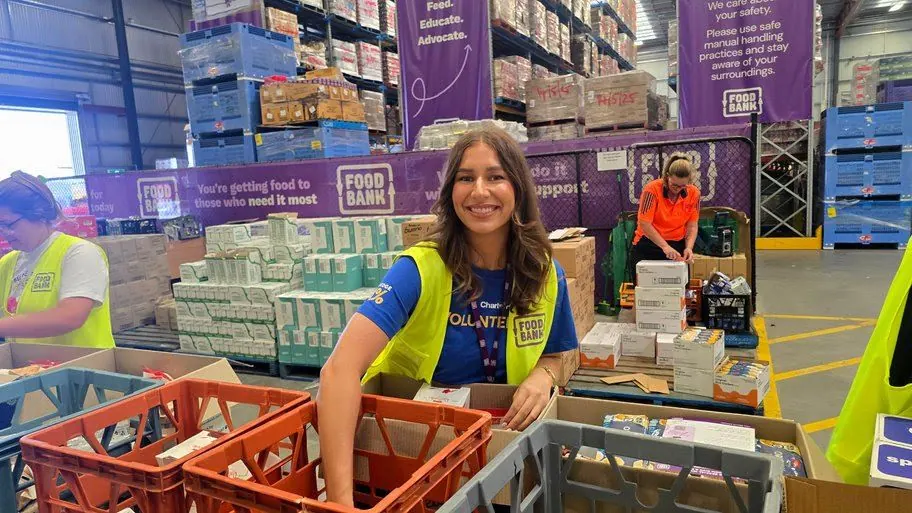 A volunteer packing Give A Feed hampers at Foodbank WA